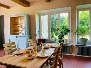 Villers-AllerandLa Bastide Champenoise - Chambres d'hôtes的一间带木桌和窗户的用餐室