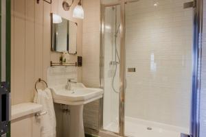 韦斯特勒姆The George & Dragon的白色的浴室设有水槽和淋浴。