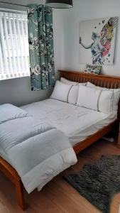 斯旺西2 bedroom Chalet all to yourself, free parking, dogs welcome的一间卧室配有一张带白色床单的大床