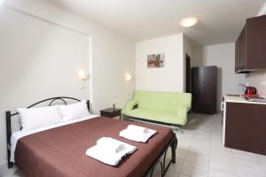 帕利乌里翁AVRA STUDIOS的酒店客房,设有一张床铺和一张绿色沙发