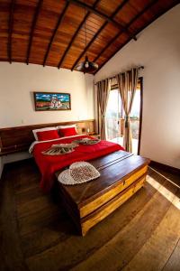 拉夫拉斯诺瓦斯Horizonte de Lavras的一间卧室配有一张带红色枕头的大型木制床。