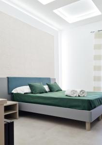 索伦托RossHouse的一间卧室配有一张带绿床单和枕头的床。