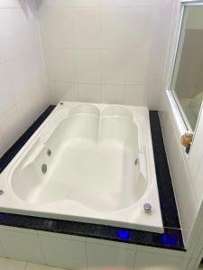 布拉干萨-保利斯塔Green It Motel & Hotel的浴室设有白色浴缸及镜子