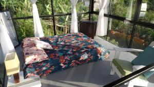 帕尔米拉Cristal House Glamping at Villa Migelita Ecolodge的床上配有鲜花棉被和枕头