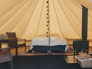 HattfjelldalVillmarksgård camping的帐篷内一间卧室,配有一张床