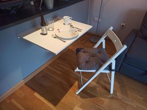 巴利亚多利德Piscina en la Ciudad的一张带椅子的白色桌子和一张带盘子的桌子