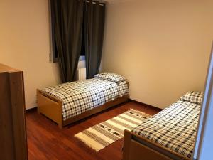 巴尔齐奥Cozy Apartment Barzio的客房设有两张床和窗户。