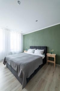 塔尔西Apartaments Nr.33 (Viesu Nr.3)的一间卧室设有一张大床和绿色的墙壁