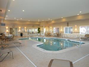 阿尔派恩阿尔派智选假日套房酒店的酒店的大型游泳池配有桌椅