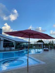 巴拉多库努Casa Alto do Cunhau的游泳池旁的红伞