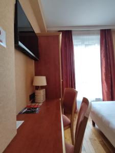 布雷斯特沃班酒店的酒店客房设有一张桌子、一张床和一个窗户。