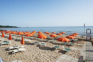 维耶斯泰迪奧梅蒂度假村的海滩上的一把遮阳伞和椅子