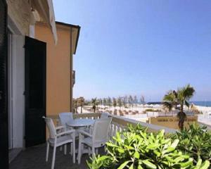 圣温琴佐自由别墅酒店的一个带桌椅和海滩的阳台