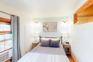 博兹曼Grand Avenue Retreat的一间卧室配有一张带两盏灯的床和一扇窗户。