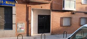 马德里Habitación CDV的砖砌的建筑,上面有黑色的门