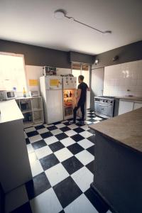 门多萨寒意客栈旅馆 的站在厨房里的人,看着冰箱