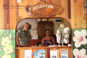 拉迪格岛马斯顿度假屋的站在柜台后面的男人和女人
