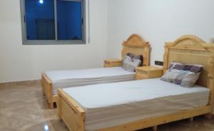 胡塞马Superbe Appartement的带窗户的客房内设有两张单人床。