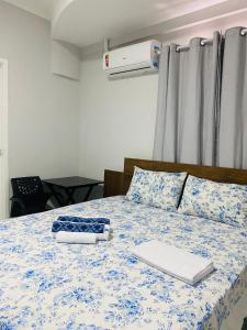 卡宁德圣弗朗西斯科Pousada Sertaneja的一间卧室配有一张带蓝色和白色棉被的床