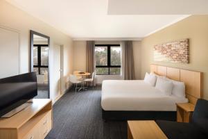 悉尼Mercure Sydney Macquarie Park的配有一张床和一台平面电视的酒店客房
