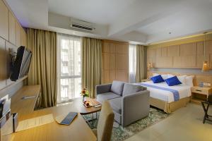 巴厘巴板Golden Tulip Balikpapan Hotel & Suites的酒店客房配有一张特大号床和一张书桌