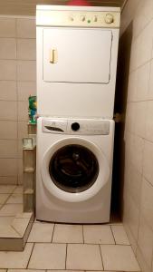 PiraeTokerau Tahiti的厨房里配有白色的洗衣机和烘干机