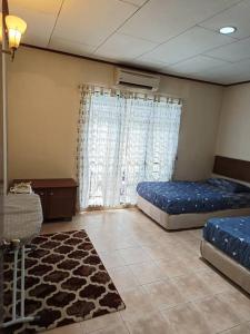 Kampong Alor GajahA'Famosa Villa 884的大房间,设有两张床和地毯