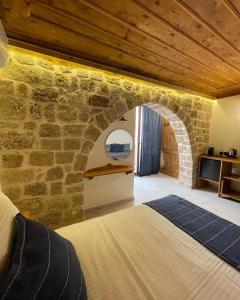 罗德镇Midgard Suites (Medieval Town)的一间卧室设有石墙和一张床