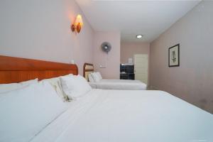 珍南海滩Mila Motel 2的一间卧室配有两张带白色床单的床