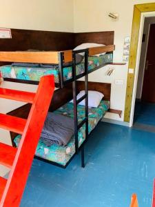 勒帕莱Auberge de Jeunesse HI Belle-Île-en-Mer的红色梯子的客房内设有两张双层床