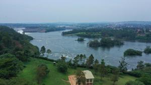 金贾Jinja Nile Resort的享有河流美景,拥有房屋和树木