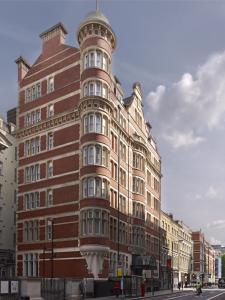 伦敦Thistle London Holborn的城市街道上一座高大的砖砌建筑