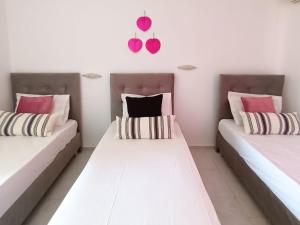 拉加纳斯Lecini Studios的配有粉红色和黑色枕头的客房内的两张床
