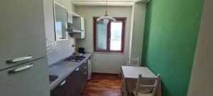 维耶斯泰Vista stupenda sul mare的厨房设有绿色的墙壁、桌子和窗户