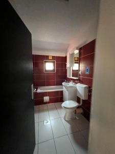 萨拉热窝Hotel Begić的浴室配有卫生间、盥洗盆和浴缸。