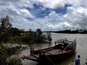 KākdwīpSatrangi Homestay Sundarban的船停靠在河岸边