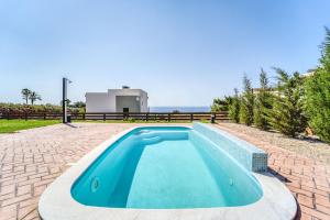 吉奥塔略Heliophos Villa Amalthia的一座游泳池位于一座带房子的庭院的中央