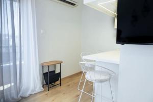 科莫蒂尼Cozy Studio In The Heart of City的配有桌椅和电视的客房