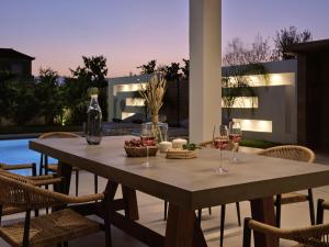 扎金索斯镇Anthis Luxury Villa的露台上的桌子和酒杯