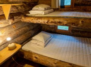 萨利色尔卡Arctic Log Cabins的小木屋内的两张双层床位 - 带桌子