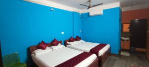 黎明之村Selvasi Beach Cottage的一间卧室设有两张带蓝色墙壁的床