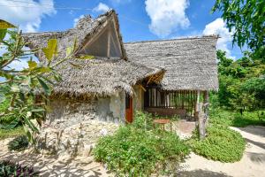 米查维AFYA Village at the sea的一座带稻草屋顶的老房子