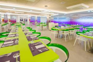 阿尔考斯布里瑟维集团罗马纳酒店的用餐室配有绿色桌子和白色椅子
