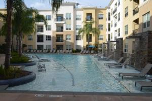 休斯顿市中心区域公寓的一座带椅子和棕榈树的游泳池以及建筑