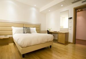 布林迪西维吉尔宫酒店的一间卧室配有一张床、一张书桌和一张书桌