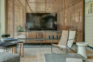 金沙Umani Hotel - Free Beach - Free Parking的一间带电视和椅子的客厅