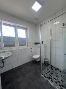 新明斯特Motel am Outletcenter的浴室配有卫生间、盥洗盆和淋浴。