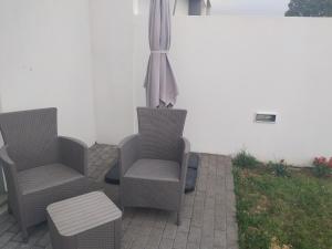 坎普自由鎮Brava的庭院配有两把椅子、一张桌子和一把遮阳伞