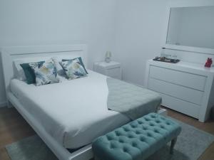 坎普自由鎮Brava的卧室配有白色的床和蓝色凳子