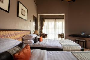 Murchison Falls National ParkSambiya River Lodge的酒店客房设有两张床和窗户。